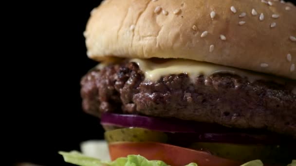 Cheeseburger auf schwarzem Hintergrund. - Filmmaterial, Video