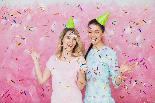 Two happy girls celebrate birthday party with cupcake confetti a - Photo, Image
