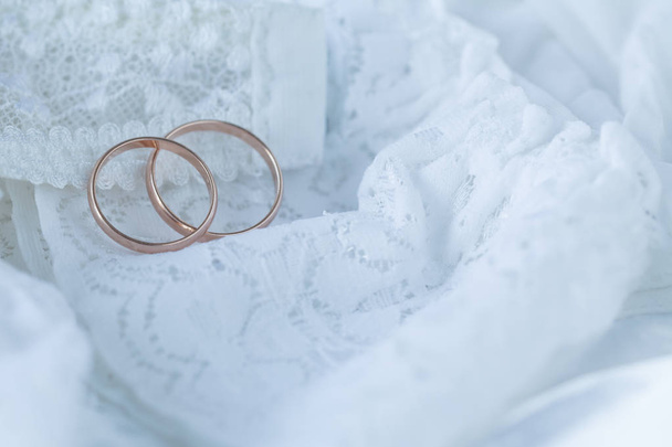 gold rings on white lace fabric - Foto, imagen