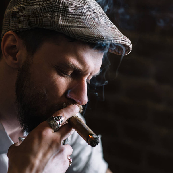 A young bearded man smoking a cigar in a pub - Foto, Imagem