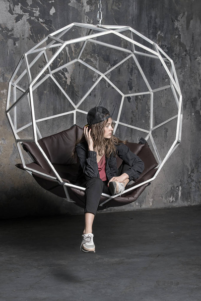 pretty woman in cap in geometric chair - Photo, Image