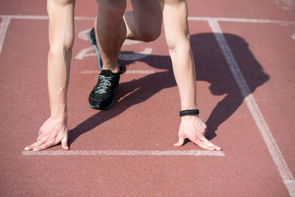 man runner with muscular hands, legs start on running track - Φωτογραφία, εικόνα