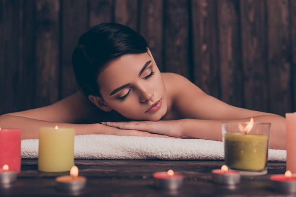 Beautiful pretty relaxed young woman laying in spa salon with cl - 写真・画像