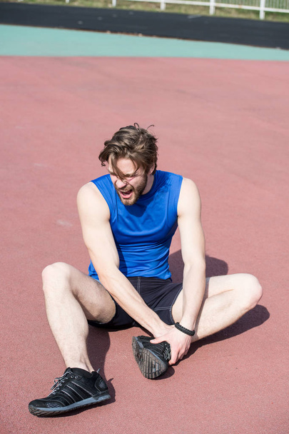 injured runner on running track feeling pain of broken leg - Фото, изображение