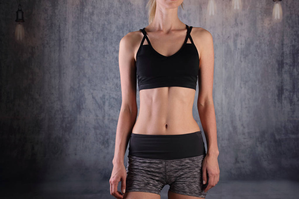 Sport, fitte Frau. Fit weiblicher Dody mit perfekter Bauchmuskulatur auf grauem Hintergrund. Ernährung, Fitness, aktives Lifestylekonzept, - Foto, Bild