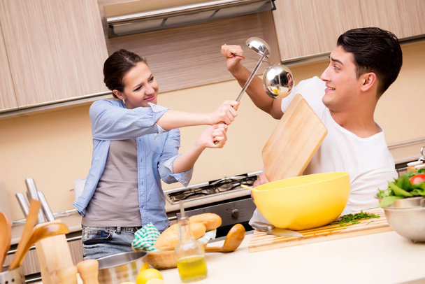 Młoda rodzina robi zabawną walkę w kuchni - Zdjęcie, obraz
