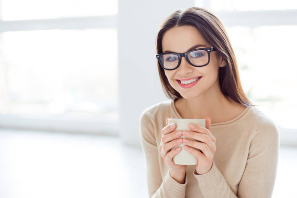 Young smart successful woman in glasses having break, holding cu - Фото, изображение