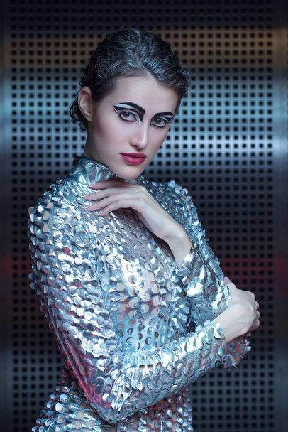 Portrait of young cyber woman in silver futuristic costume with bright makeup. - Photo, Image