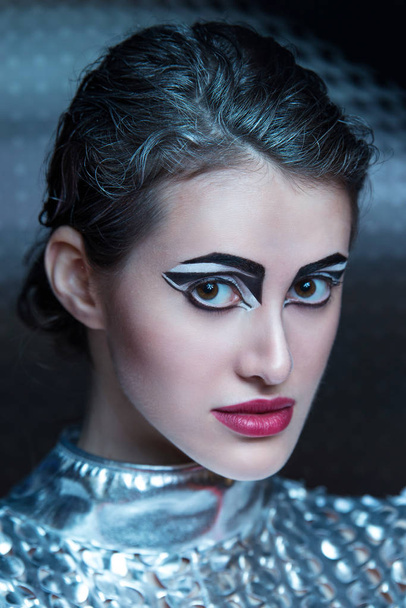 Portrait of young cyber woman in silver futuristic costume with bright makeup. - Foto, Imagem