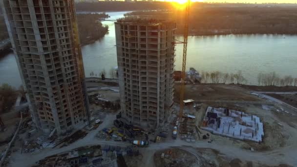 Luchtfoto van de bouwplaats met kranen en werknemers bij zonsondergang. - Video