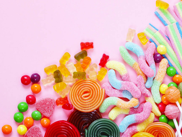Colorful candy and fruit jelly sweets on a pink background - Photo, Image