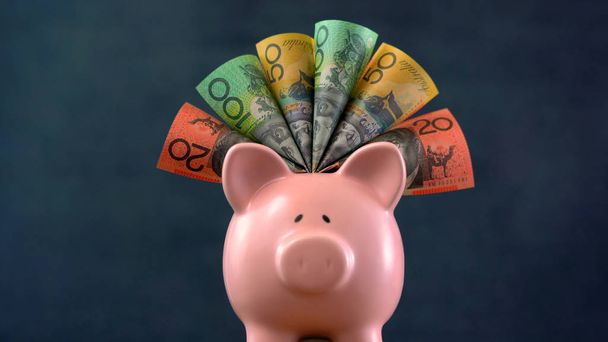 Rózsaszín Piggy bank pénzt koncepció a sötét kék háttér - Fotó, kép