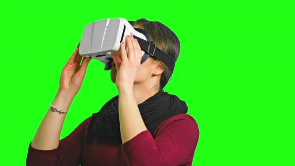 Mujer girando la cabeza con un auricular VR encendido
. - Imágenes, Vídeo