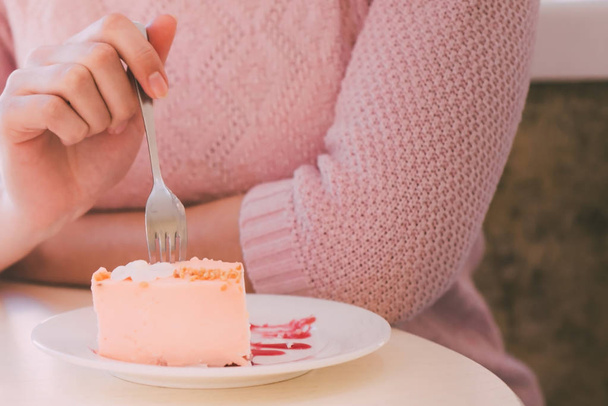 Kobieta na stole jedzenie ciasto widelcem - Zdjęcie, obraz