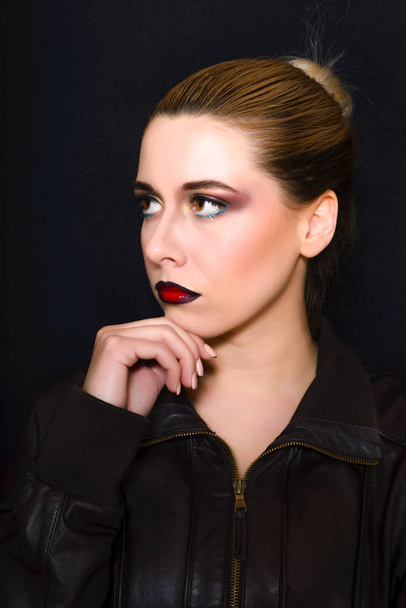 Rubia con el pelo recogido en un moño y maquillaje profesional con labios de color rojo oscuro
  - Foto, Imagen