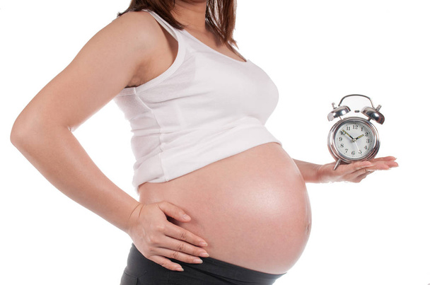 Kobieta w ciąży, trzymając zegar czeka na narodziny - Zdjęcie, obraz