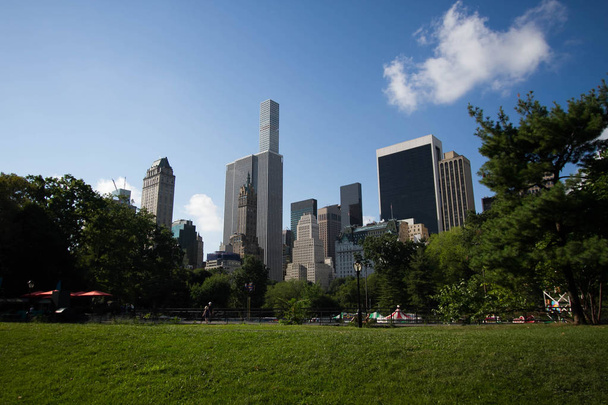 Buildings of Manhattan behind Central Park with blue sky - Fotoğraf, Görsel