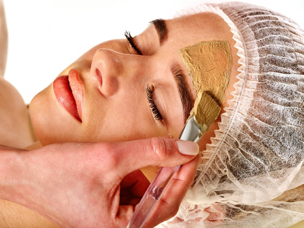 Máscara facial de barro de la mujer en el salón de spa. Masaje facial
 . - Foto, imagen