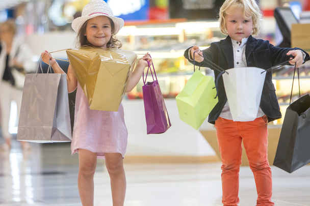 Τα παιδιά ψώνια. χαριτωμένο μικρό κορίτσι και αγόρι για ψώνια. - Φωτογραφία, εικόνα