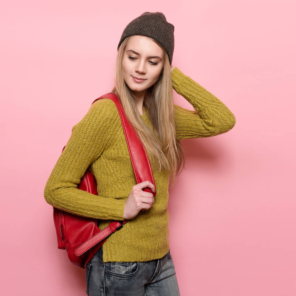 Beautiful young adult student girl with backpack ready to go study. Happy smiling Woman wearing casual outfit posing near pink wall. - Zdjęcie, obraz