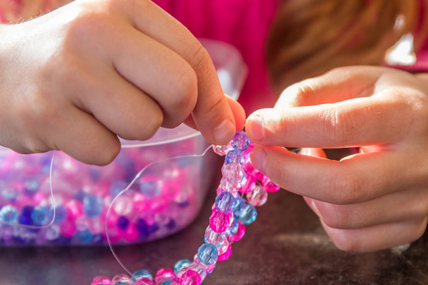 young child girl making bead bracelet - Photo, Image