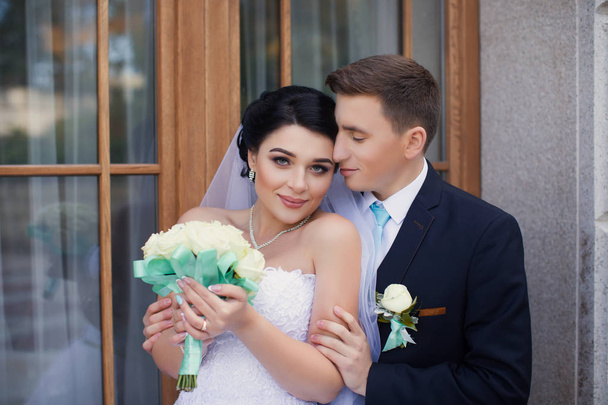 Ο γαμπρός αγκάλιασε τρυφερά τη νύφη - Φωτογραφία, εικόνα