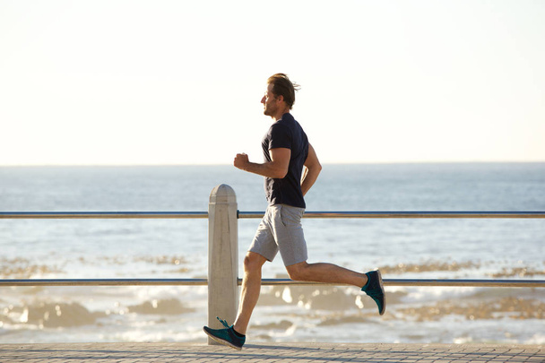 active man running by sea - Photo, Image