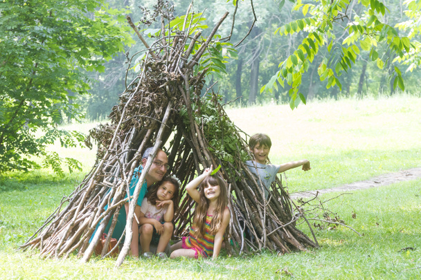 niños jugando al lado de la casa palo de madera
 - Foto, imagen