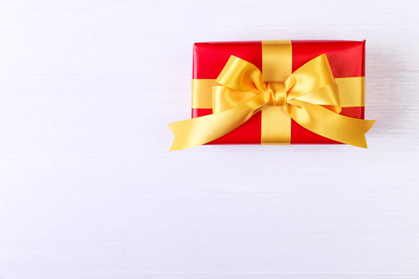 Gift box with yellow bow. Red present package. - Foto, afbeelding