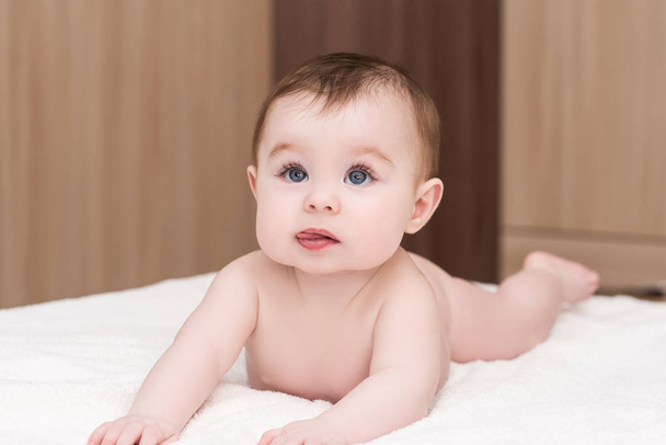 baby girl lying on blanket and show tongue - Foto, immagini