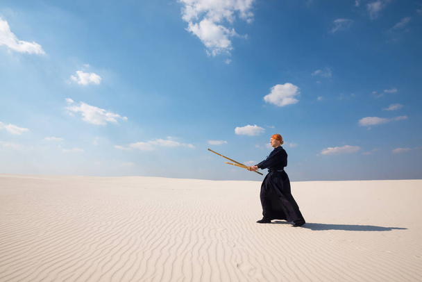 Caucasian man with shinaiin a desert - Foto, imagen