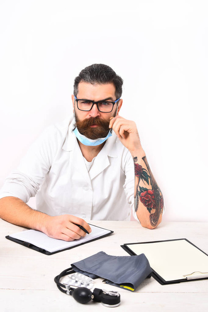 Bearded caucasian doctor sitting at table - Photo, Image