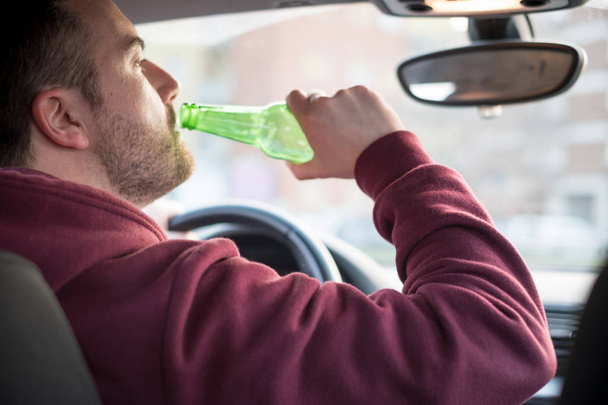 Μεθυσμένος άντρας οδήγηση του αυτοκινήτου και την κατανάλωση - Φωτογραφία, εικόνα