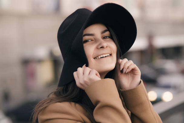 Funky woman in hat smiling and having fun, city background - Fotografie, Obrázek