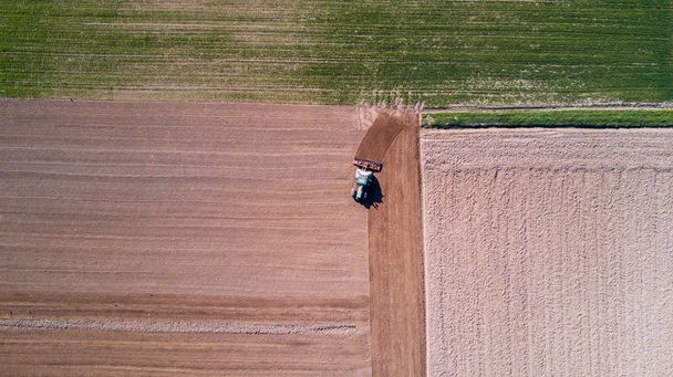 Tractor arando los campos, vista aérea de un campo arado y un tractor que siembra
 - Foto, Imagen