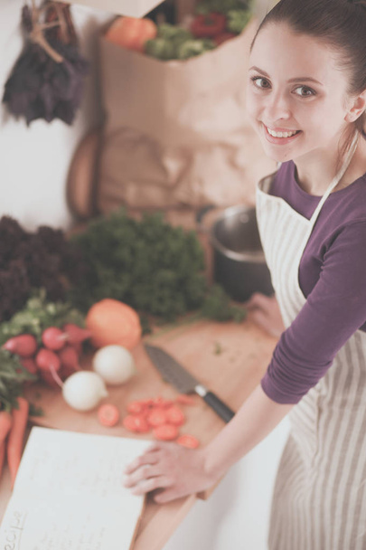 Young woman cutting vegetables in the kitchen - Foto, Imagem