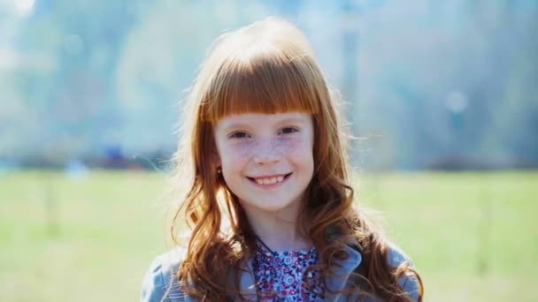 mała dziewczynka imbir z piegami uśmiechający się - Materiał filmowy, wideo