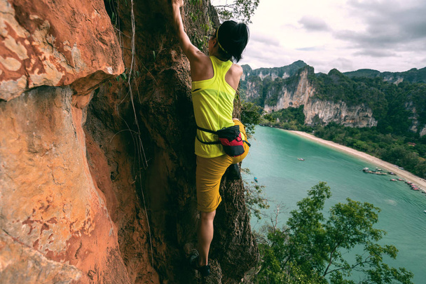 woman climbing at seaside cliff - Foto, Bild