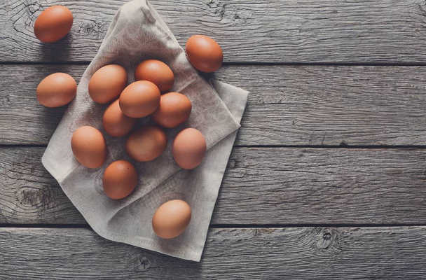 Свежие куриные коричневые яйца на льняном, органическом сельском хозяйстве
 - Фото, изображение