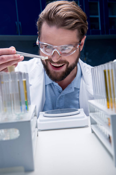 chemist in goggles with reagents - Foto, Bild
