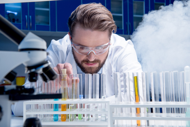chemist in goggles with reagents - Fotoğraf, Görsel