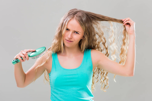 Angry woman combing hair - Foto, Imagem