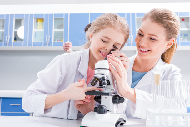 Teacher and student working with microscope  - Photo, image