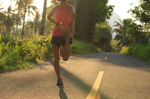 Nuori nainen juoksija venyttely jalat
  - Valokuva, kuva