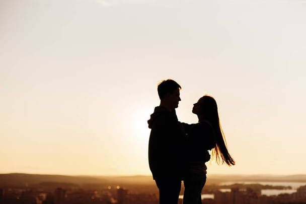 Couple embracing on a roof at the sunset - Foto, Imagen