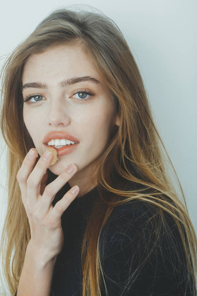Pretty smiling girl putting gel or balm on sexy lips - Fotografie, Obrázek