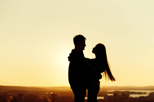 Couple embracing on a roof at the sunset - Fotografie, Obrázek