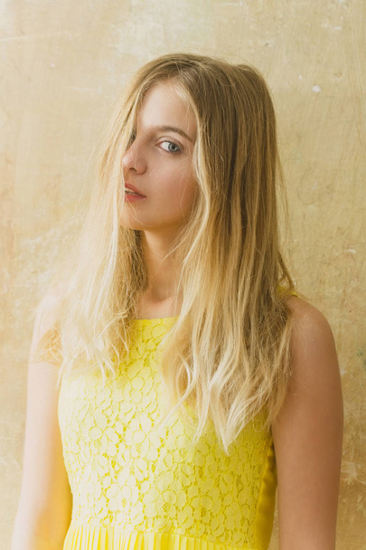 Pretty happy girl with long blonde hair in yellow dress - 写真・画像