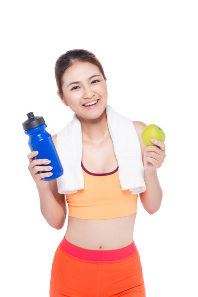 Portret van jonge aantrekkelijke Aziatische vrouw met groene apple en fles. Dieet concept. Geïsoleerd op wit. - Foto, afbeelding