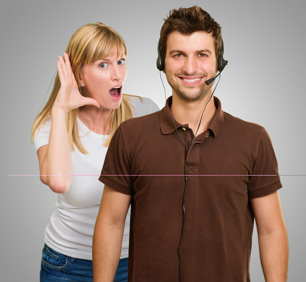 Мужчина с наушником и женщина, слушающая сзади
 - Фото, изображение
